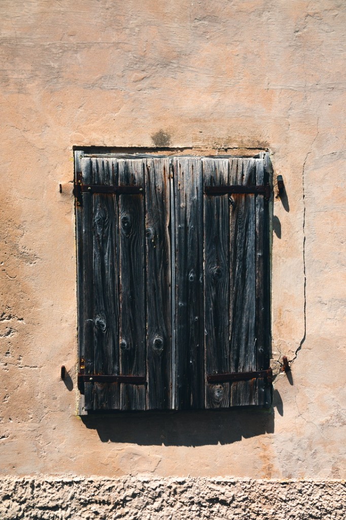 Hölzerne Fensterläden an einer sonnigen Hauswand